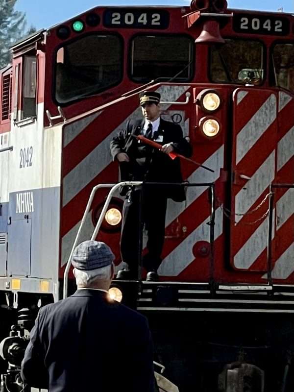 A railroad fan watches the High Peaks Limited ease into the station.