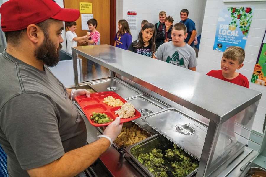 Travis King, cook manager for Willsboro Central School, serves a healthy lunch to students.
