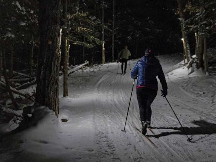 Liza Frenette (right) and John Gillis ski the James C. Frenette Sr. Recreation Trails in Tupper Lake at night