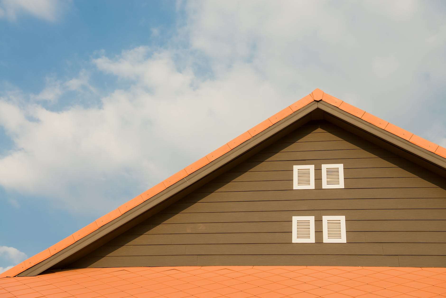 orange and gray painted roof under cloudy sky to illustrate rise in property values