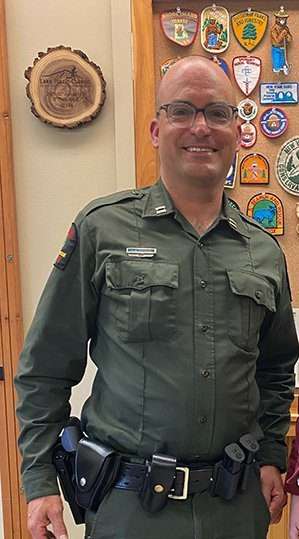 DEC Forest Ranger Capt. Chris Kostoss, who died by suicide stands in his uniform shortly before his death.