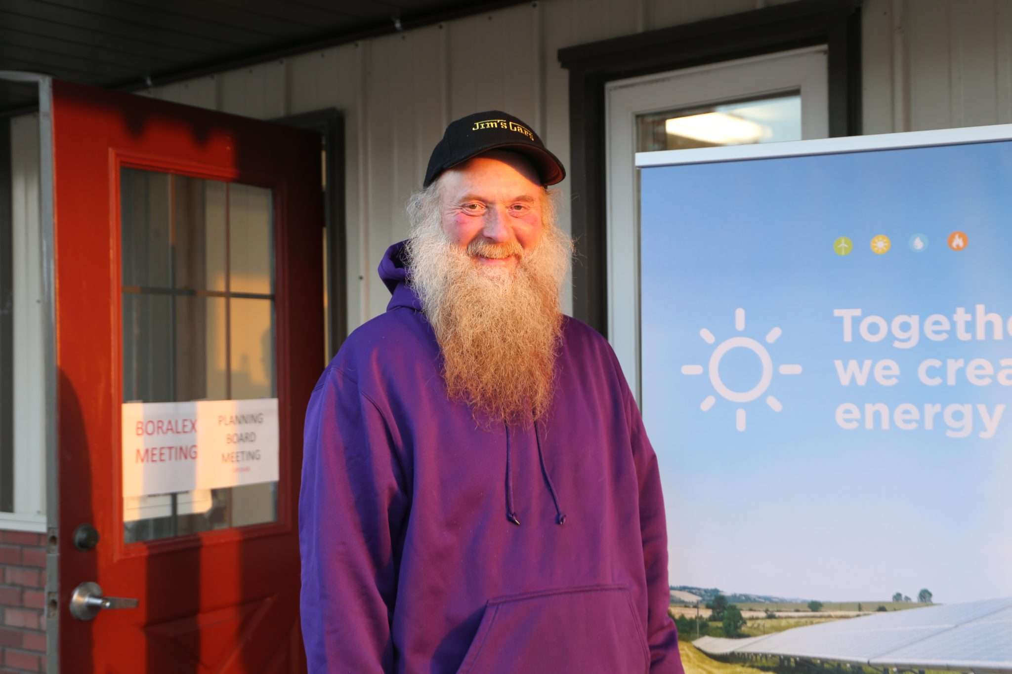 Jon Close, a farmer from Mayfield with a long beard and wearing a purple sweatshirt, stands outside the Mayfield Fire House.