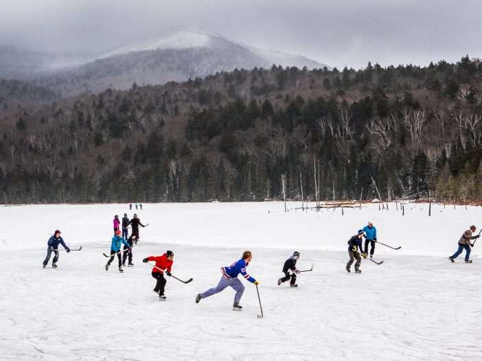 A group of 12 skaters play over frozen Holcomb Pond near Lake Placid, New York.