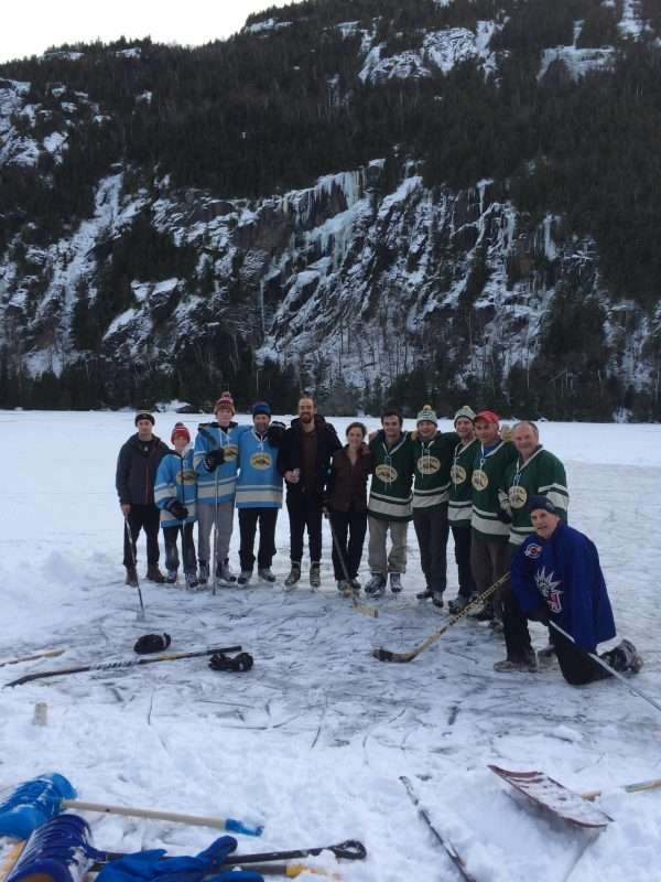 Mike Richter and a group of friends and family stand together after playing hockey on Chapel Pond in Keene. Climate change is altering the number of hours people can be outside on the ice.