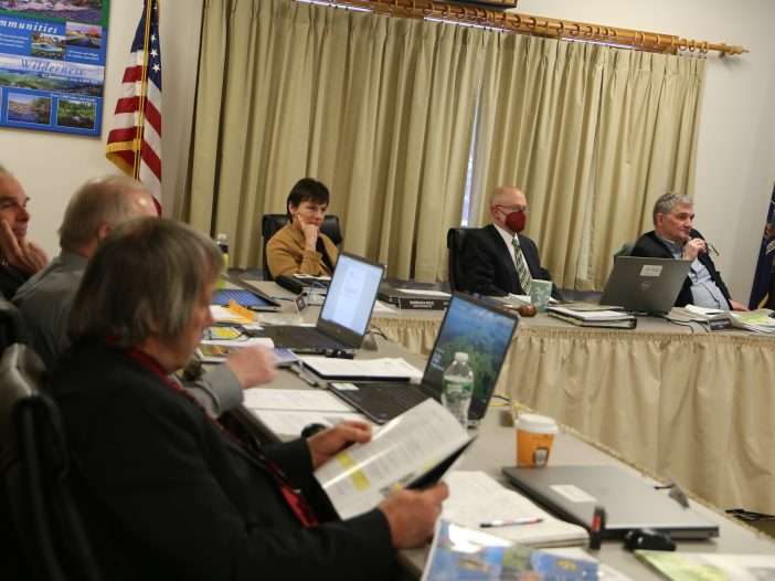 Members and staff of the Adirondack Park Agency sit around a table listening to a presentation during the March 16, 2023 meeting in Ray Brook.