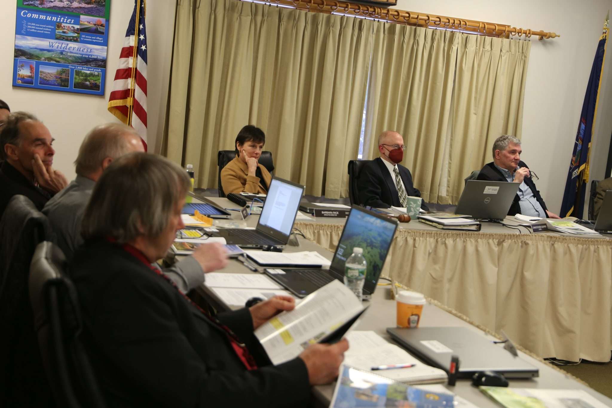 Members and staff of the Adirondack Park Agency sit around a table listening to a presentation during the March 16, 2023 meeting in Ray Brook.