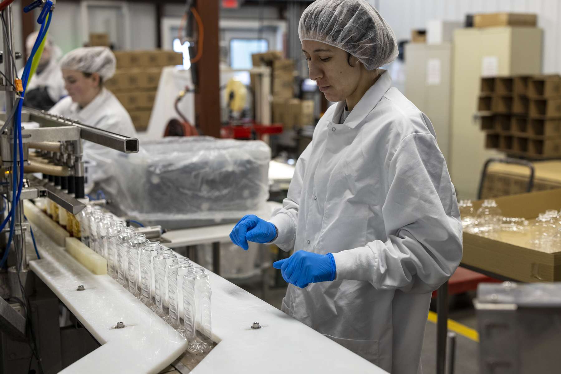 lisha Valdon sets up the bottles to be filled inside the New Leaf Tree Syrups sugar house in Lyon Mountain. Photo by MIke Lynch