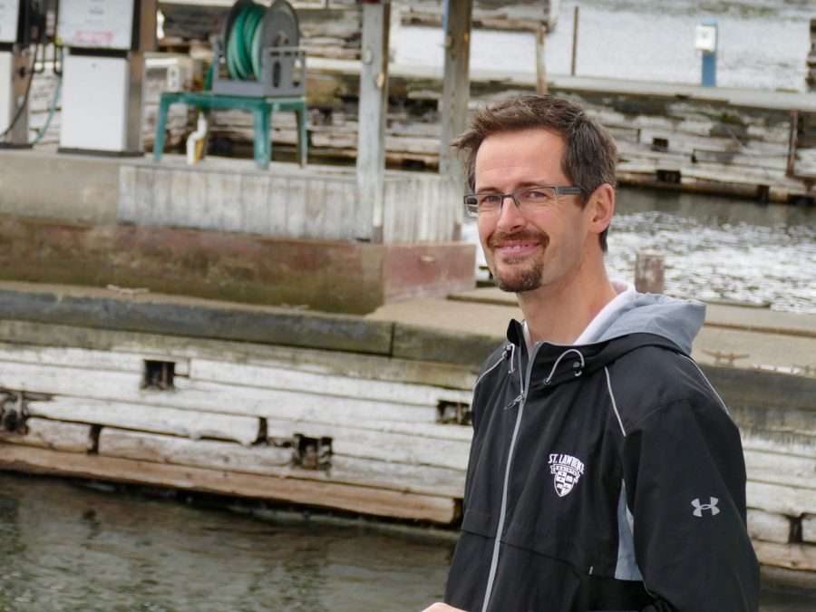 Essex Supervisor Ken Hughes, wearing a black hooded jacket posing near a dock