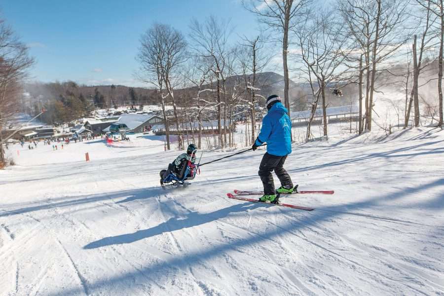 Ski instructor is tethered to the skier's bi-ski on a Gore Mountain slope. 