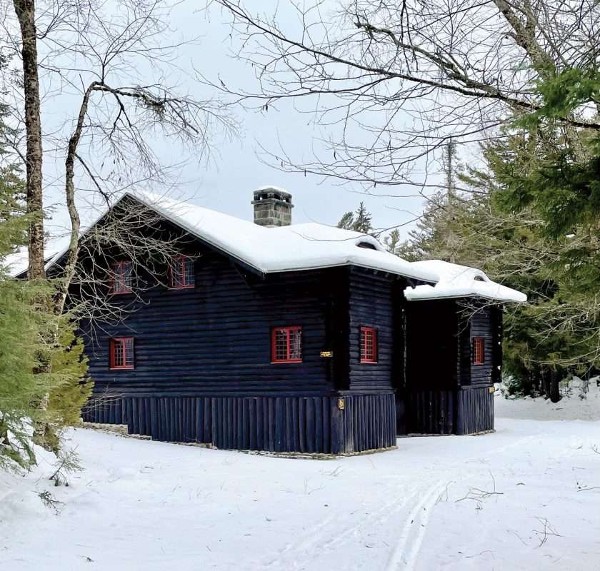 One of the historic Santanoni Great Camp buildings with snowy roof