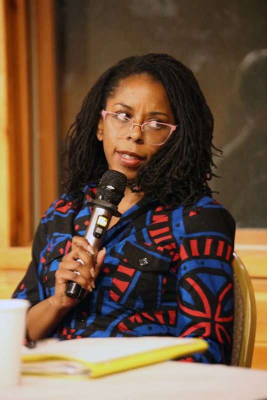 Holding a microphone, Tiffany Rea-Fisher, director of the Adirondack Diversity Initiative, speaks on a panel about diversity, equity and inclusion on Friday, March 10, 2023 at Camp Chingachgook in Fort Ann