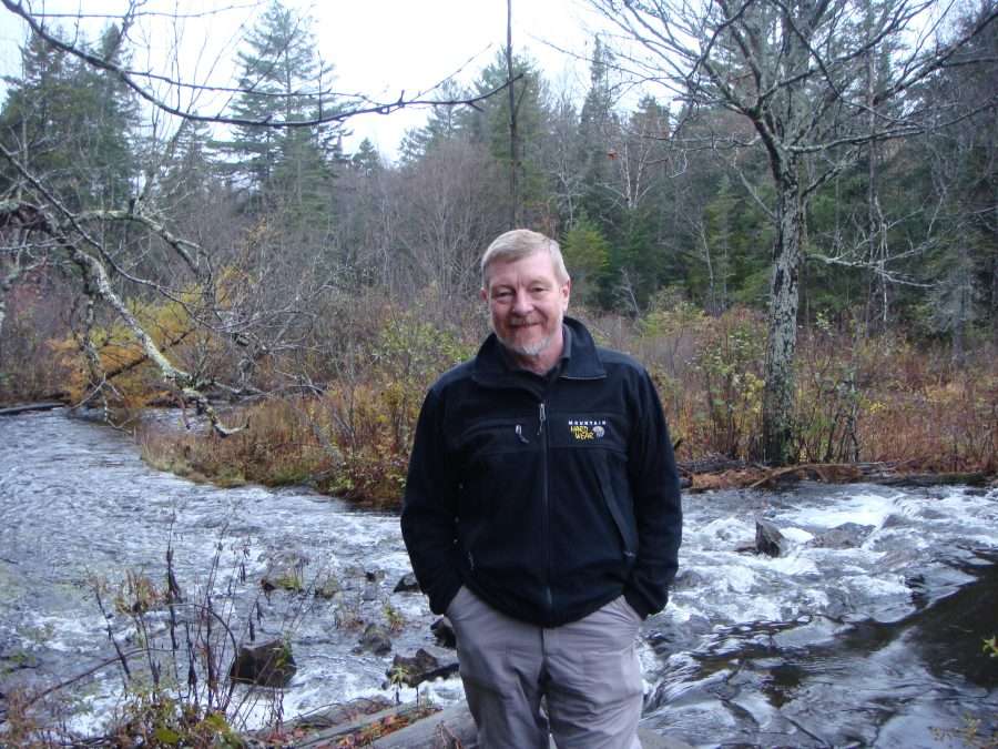 Harry Gordon stands in front of a flowing river.