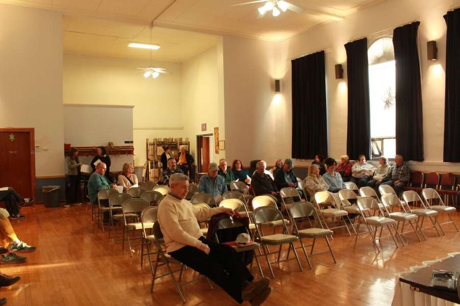 A group of community members sits in a room inside Long Lake Town Hall.
