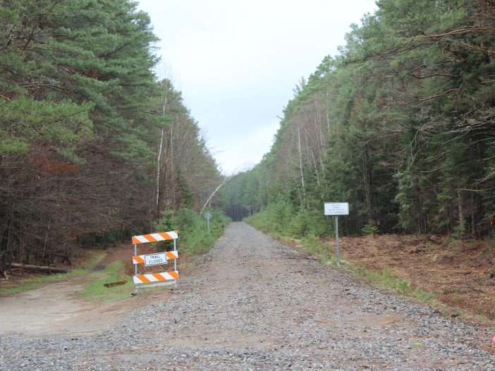 A sign that says "trail closed" is on the side of the Adirondack Rail Trail.