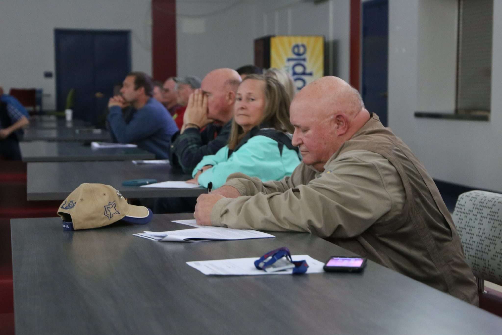 A man takes notes during a meeting inside the Broadalbin-Perth High School cafeteria.