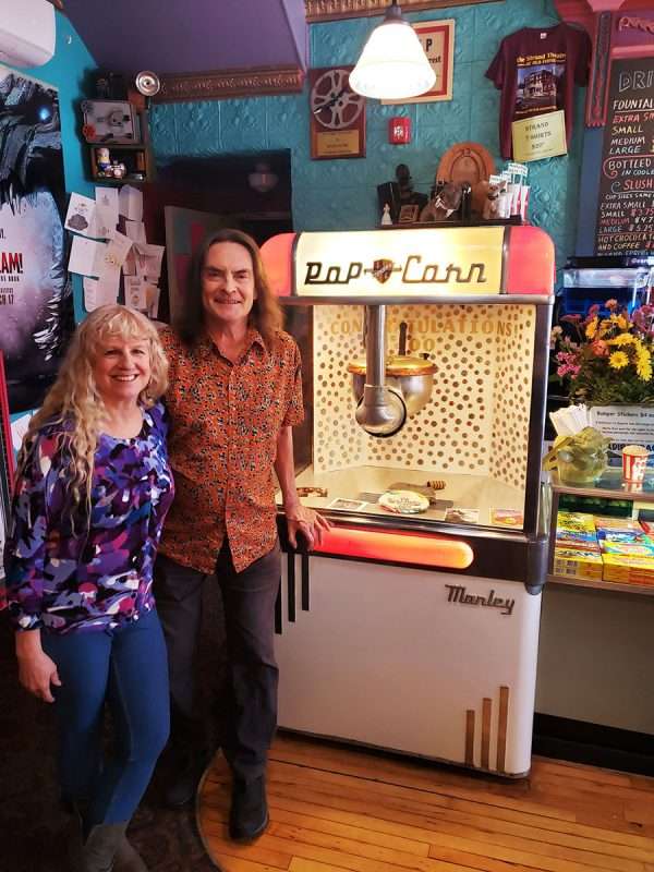 helen and bob, standing next to the popcorn machine at the strand theatre