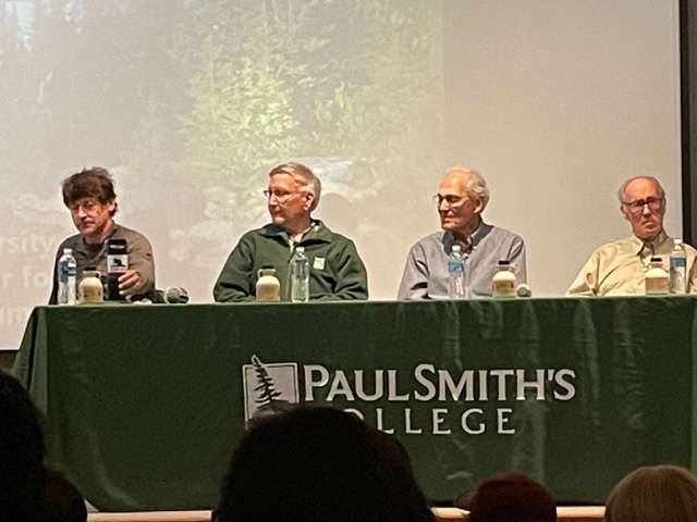 men sitting at a table with a green paul smith's college tablecloth