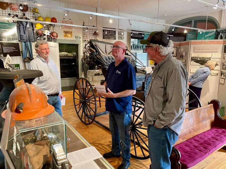 three people in a museum room