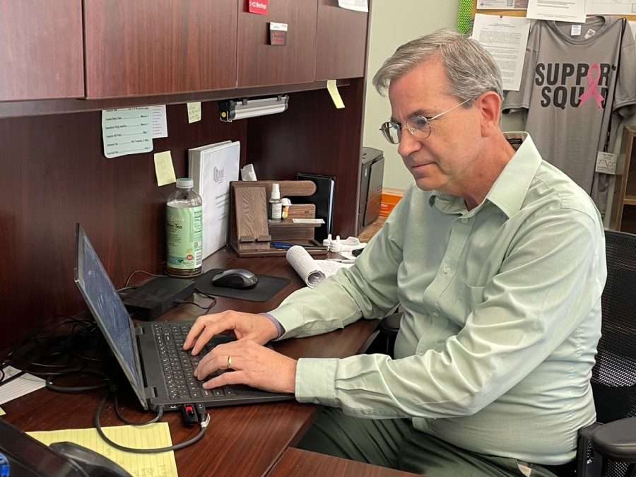 man with green shirt at laptop