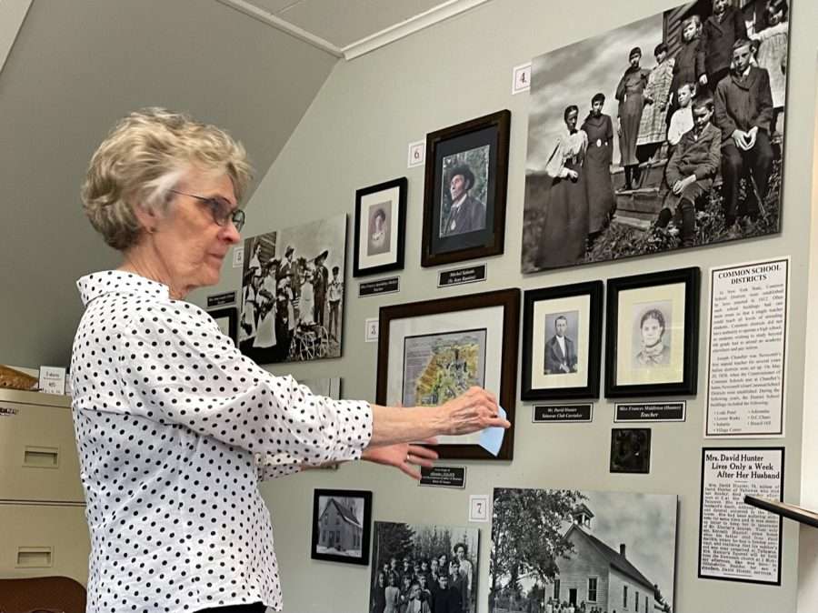 woman arranging photos on a wall