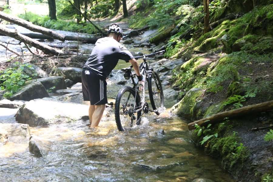 A biker wades through ankle-deep water on the Shelving Rock Falls trail on Tuesday, July 11, 2023 in Fort Ann.