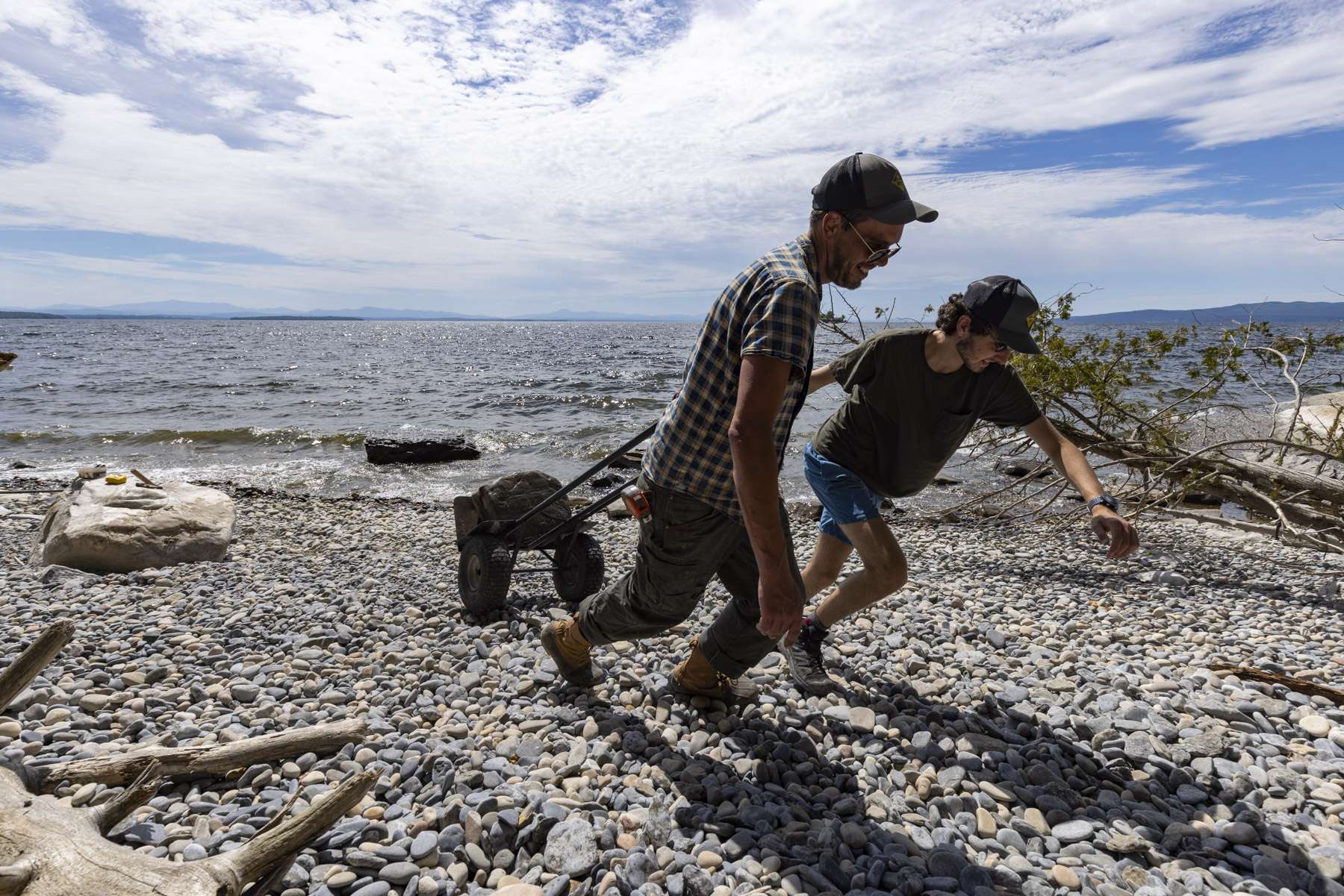Northern Forest Canoe trail crew leader Will Lockwood, right, intern Jonah Yaffe move a stone across the beach at Valcour. 