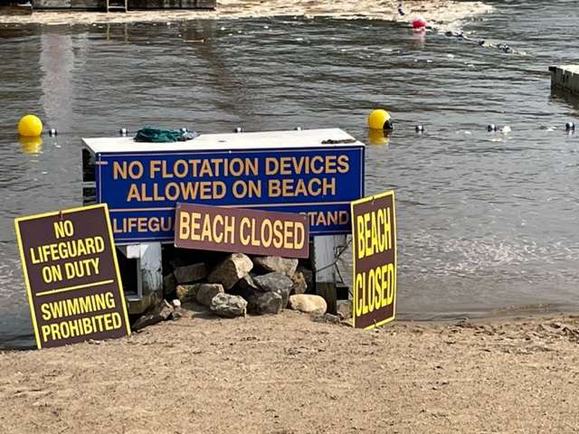 Beach closure signs in Long Lake