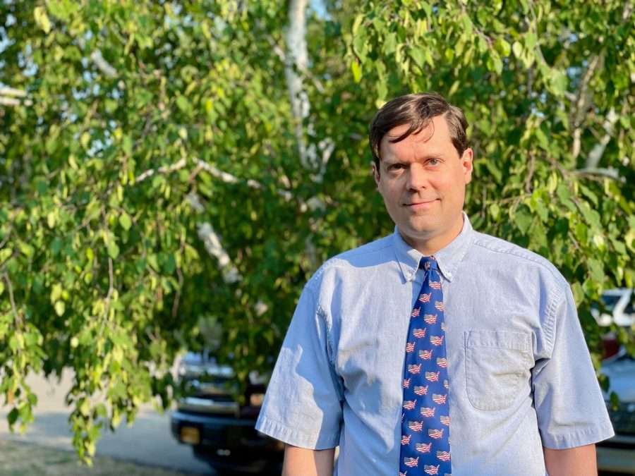 Wilmington Board Member Tim Follos wearing a blue shirt and tie with American flags on it