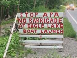 A sign says "Stop APA no barricade at Eagle Lake boat launch"