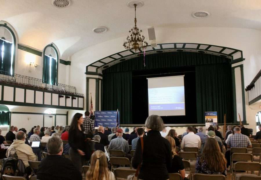 A group of people attend a meeting in an auditorium