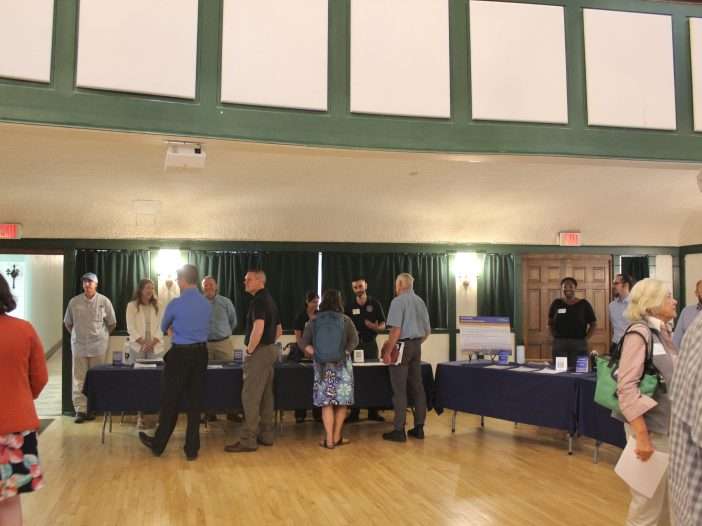 Participants speak with experts in an auditorium