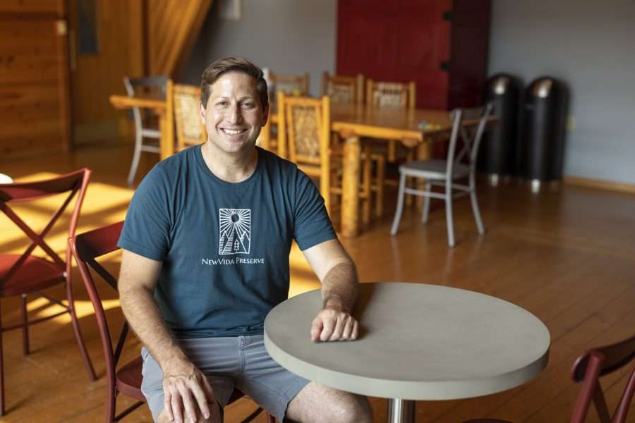 man sitting at a bistro table, smiling