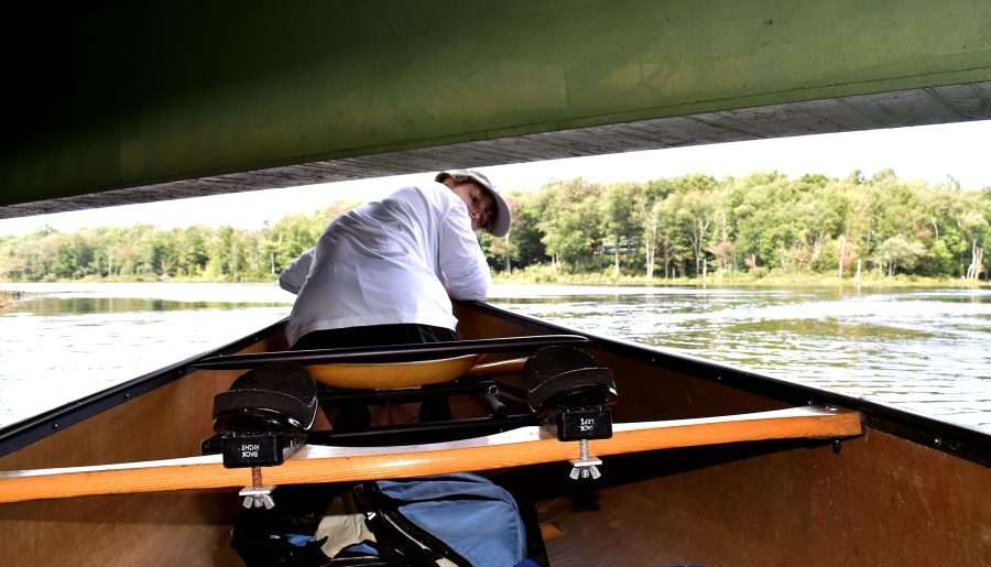 canoe going under a bridge on the oswegatchie river