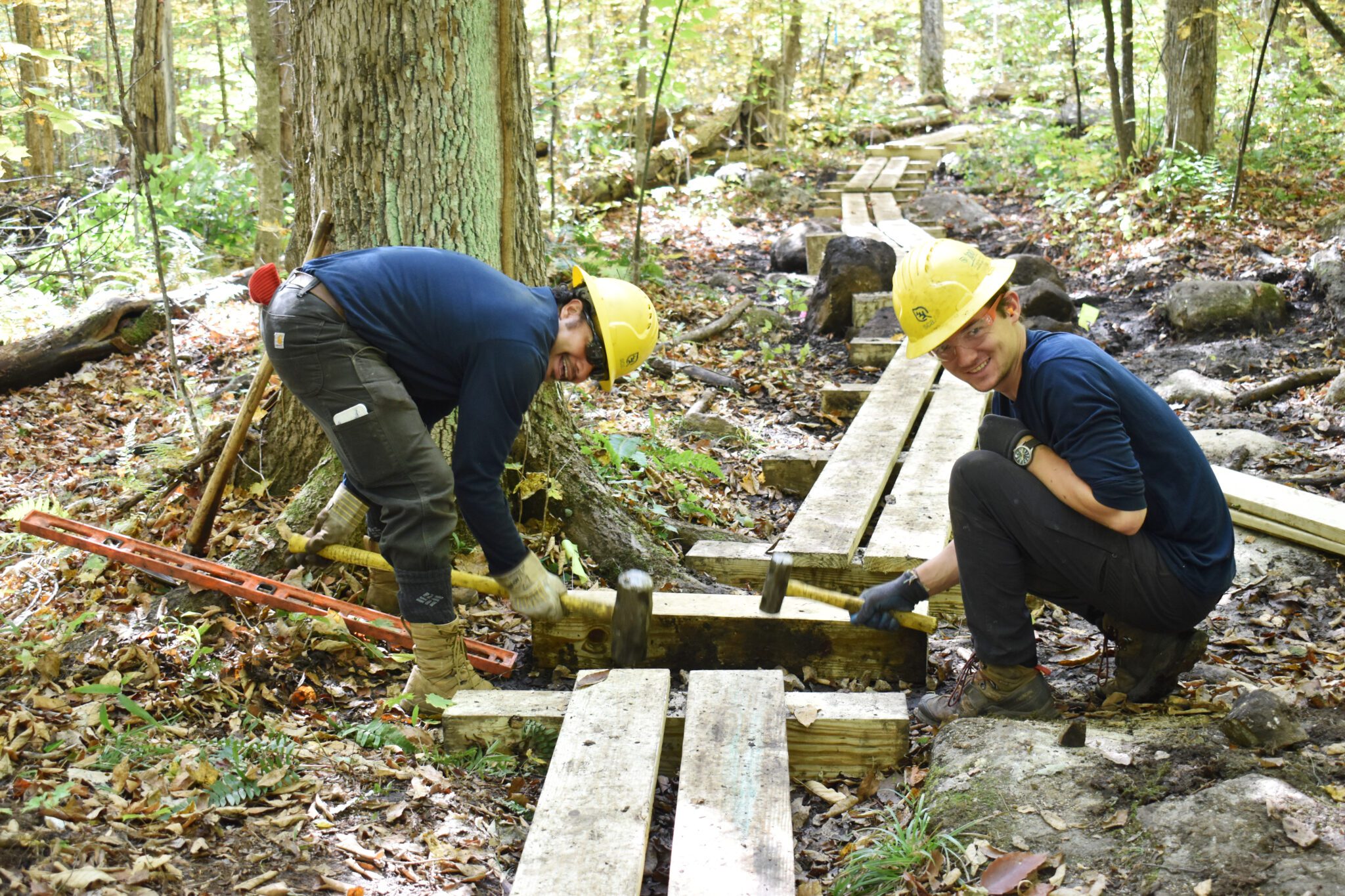 Two members of the Student Protection Society crew work on a pedestrian bridge