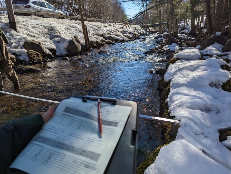 a clipboard in the foreground with stream in the background
