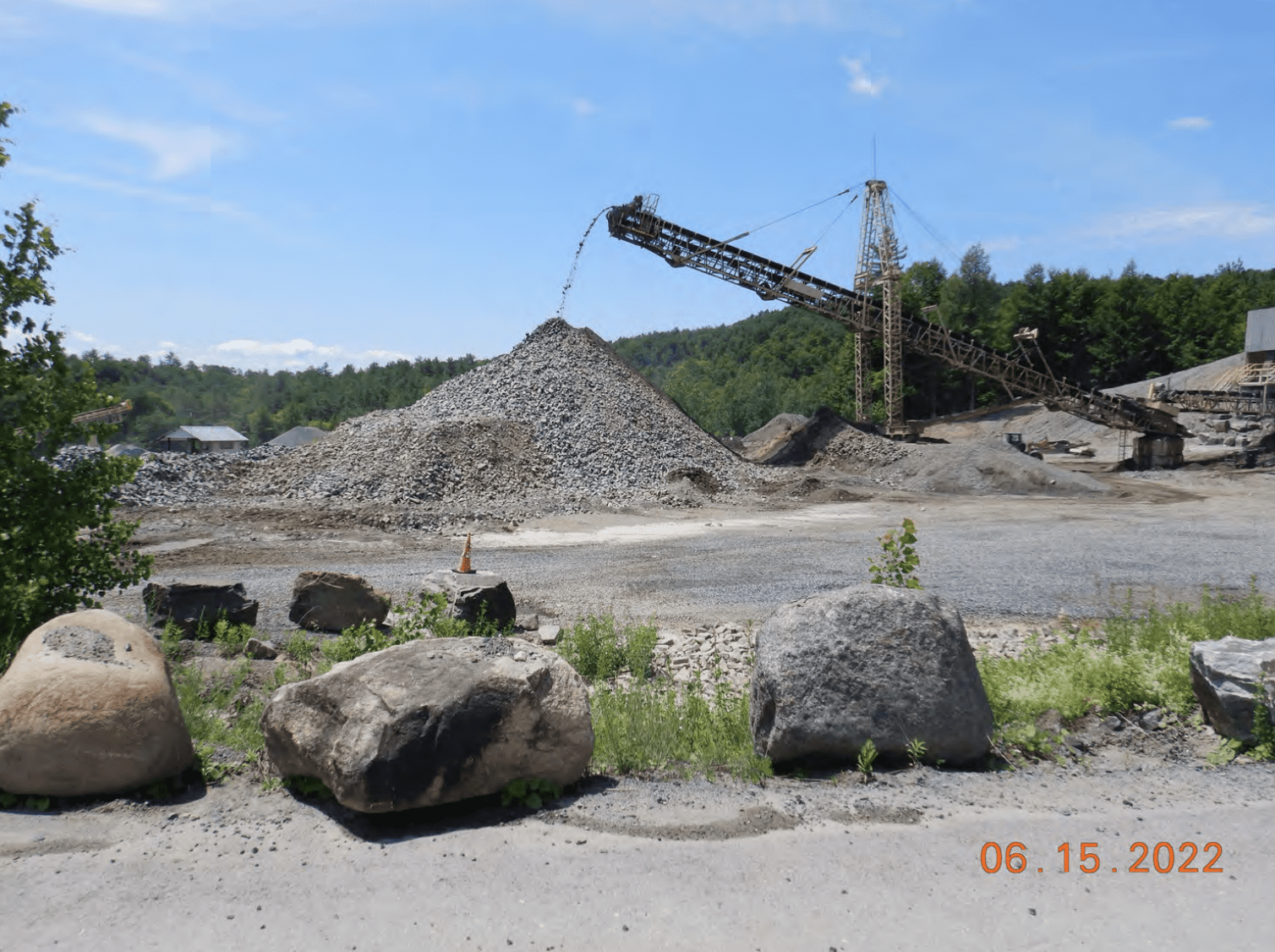 A crane over a pile of stone on a clear day