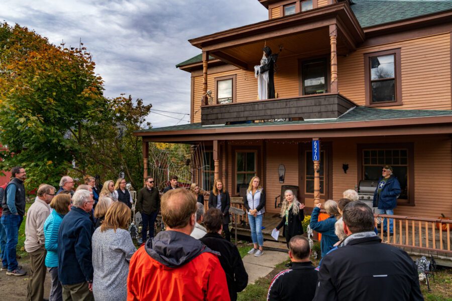 group of housing advocates standing in front of a brown house that's recently been renovated