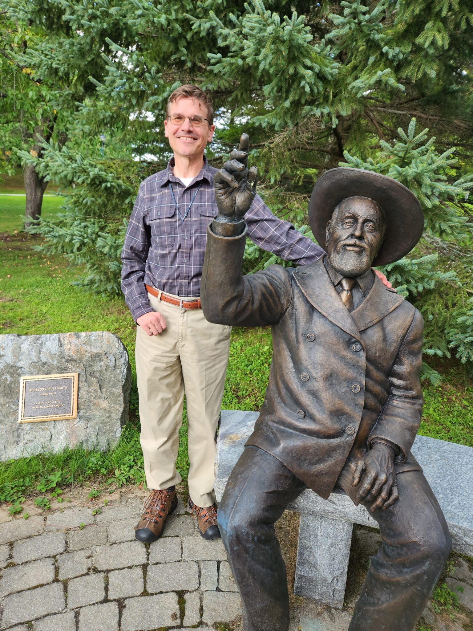 Interim Paul Smith's College President Dan Kelting at the statue of the school's namesake. Photo by James M. Odato