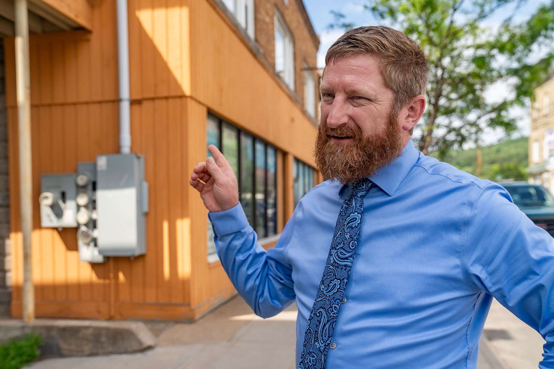 own of Jay Supervisor Matt Stanley talking about the potential for downtown revitalization in Au Sable Forks. The building behind him is a former Aubuchon hardware store that has long been vacant and it’s 3 apartments are not habitable. Stanley has applied for a New York Main Street Technical grant for planning and additional fund raising to assist building owners. Photo by Eric Teed