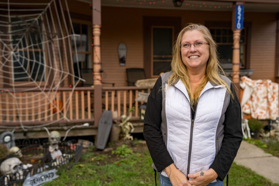 Joelle Nesbitt in front of her home in Westport, which her grandmother bought in 1954. It had fallen into disrepair with the unfolding of difficult life circumstances. Through a rehab grant with Adirondack Roots, she was able to save the house.
