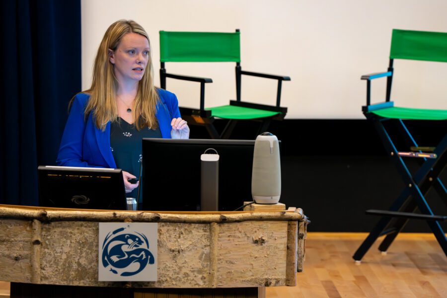 blond woman with blue blazer at a podium during "taking stock of housing" event