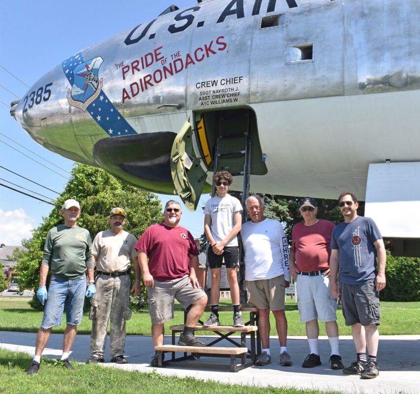 Group of people in front of the Pride of the Adirondacks airplane