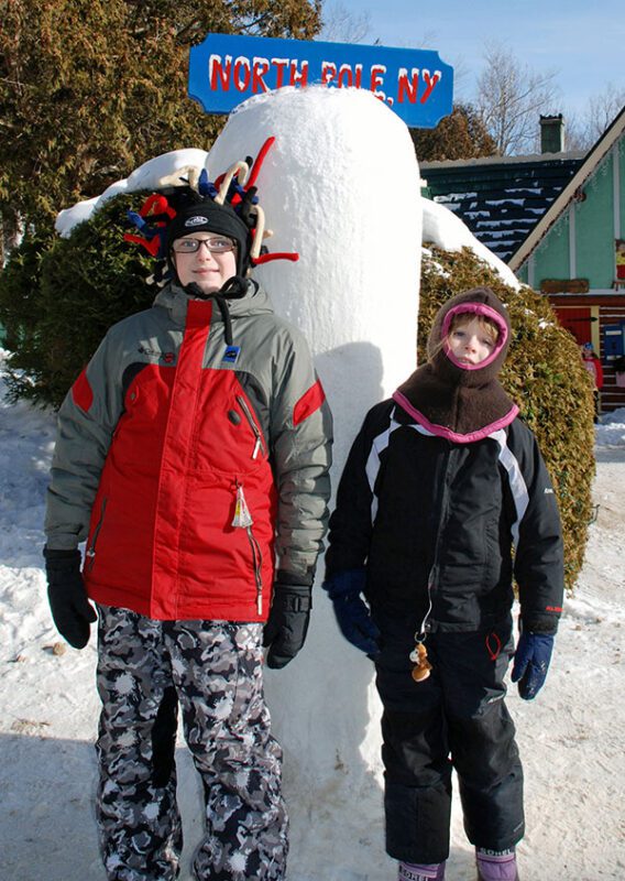 two kids in front of ice pole at santa's workshop
