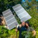 Brian McCormack and Melanie Sawyer in front of their pole-mounted tracking solar panels