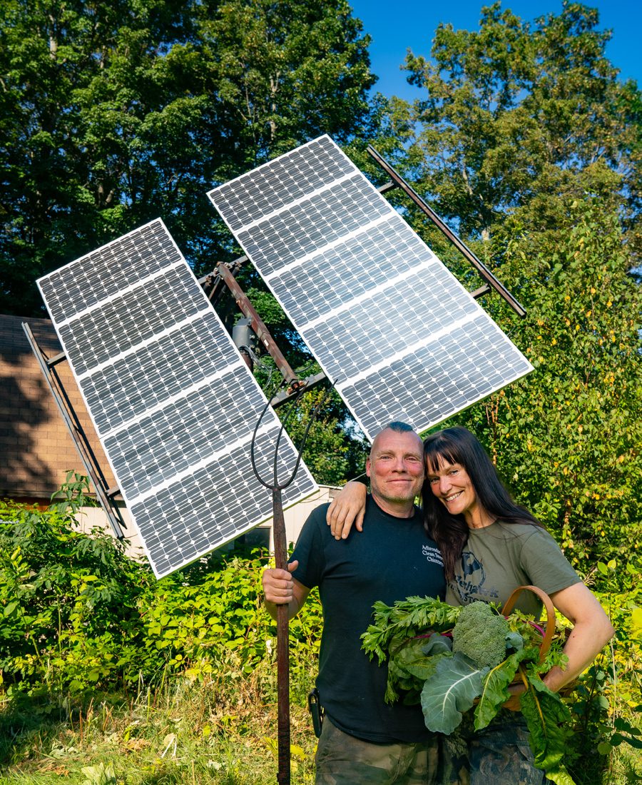 Brian McCormack and Melanie Sawyer in front of their pole-mounted tracking solar panels