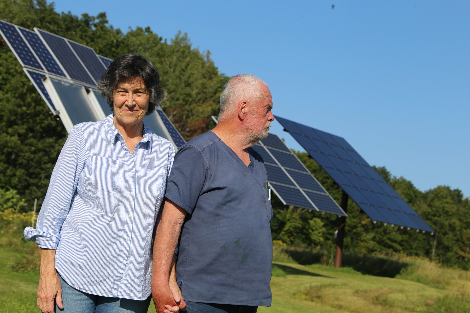 Sarah Johnston and Dave Smalley stand in front of their solar panels.