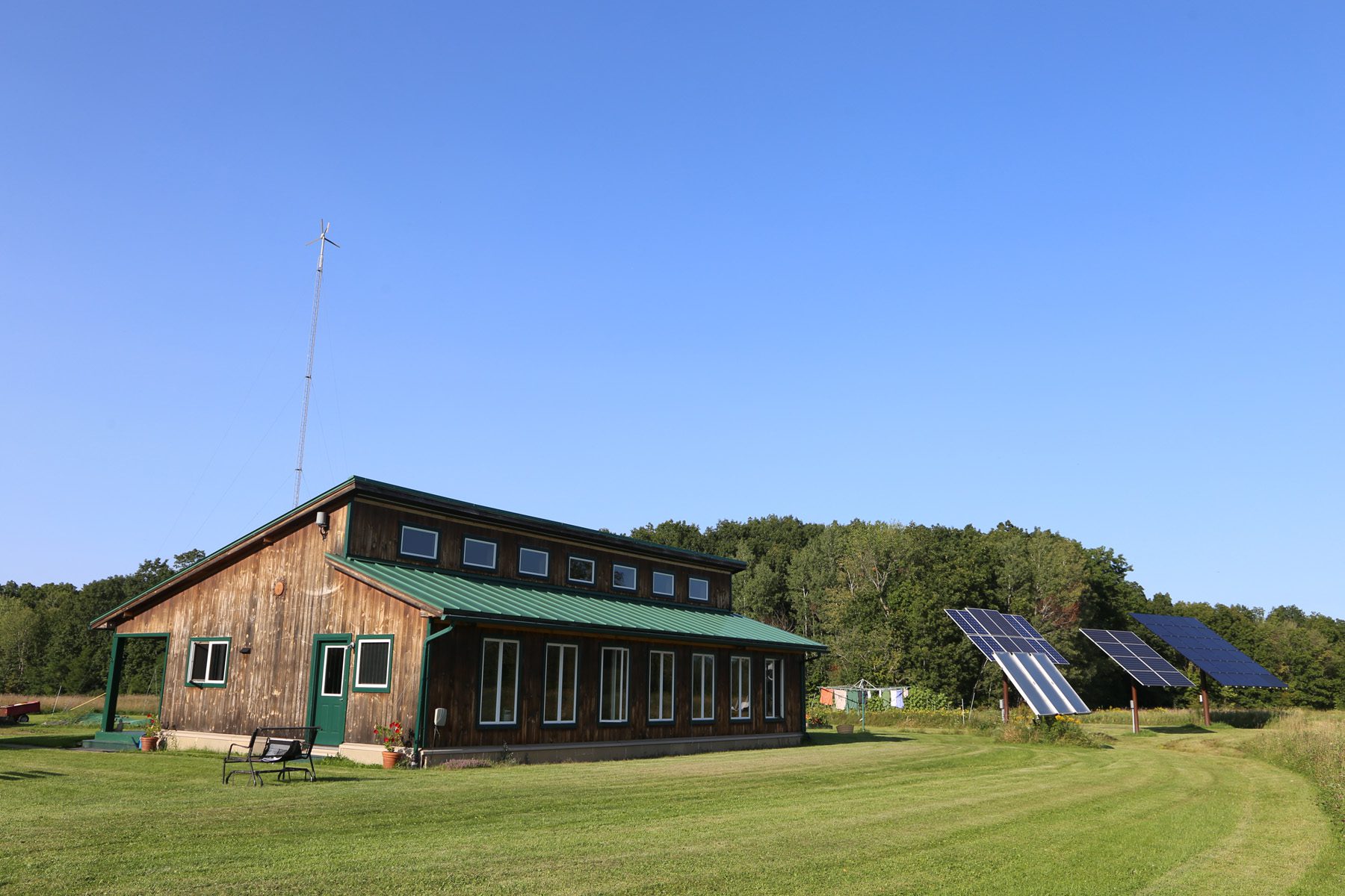 a house with solar panels and a wind turbine