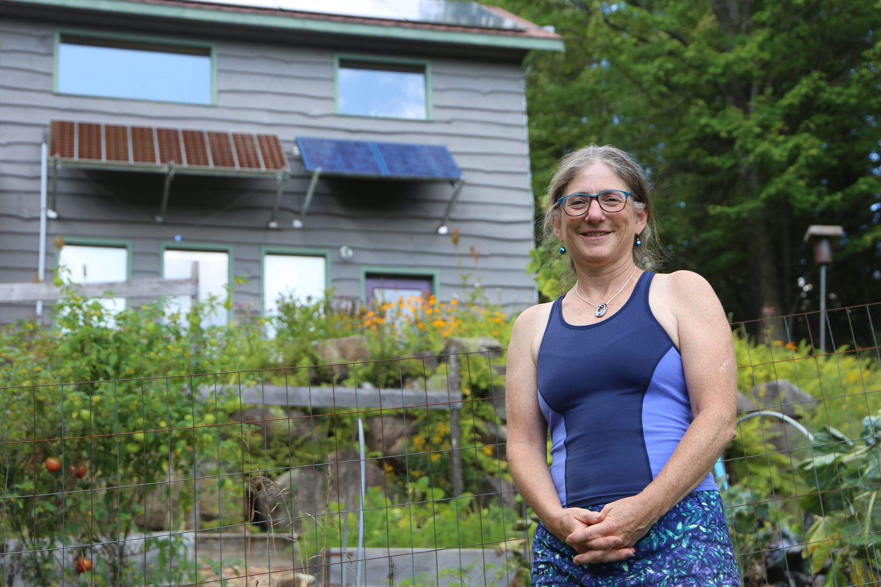 Nancy Bernstein stands in front of her home, which is powered mostly by solar panels.