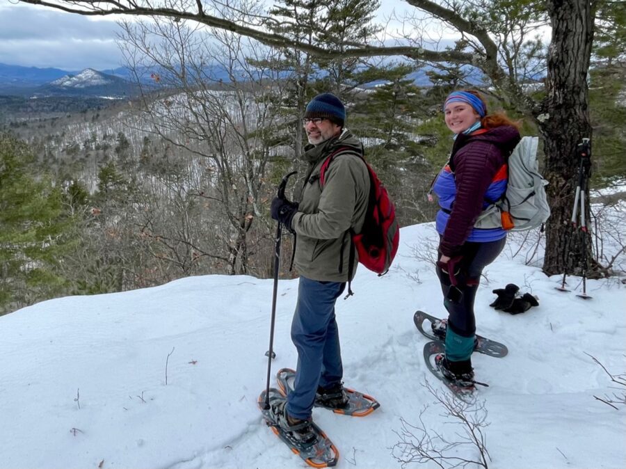 two people in snowshoes on a snowy ledge