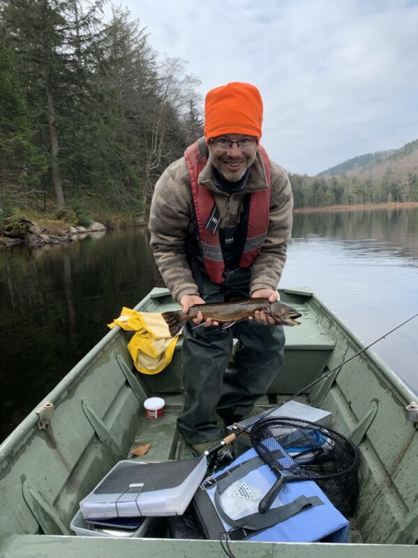 man in a boat with a trout